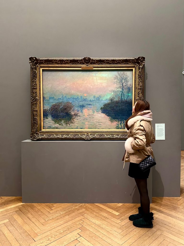 Winter museum visit while admiring an impressionist painting, wearing a cozy beige jacket and scarf. | THE DAILY HAPPINESS