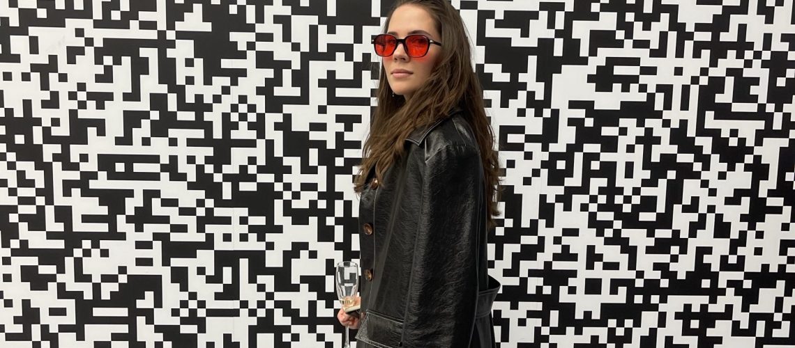 Brunette girl standing in front of a black and white pixelated wall